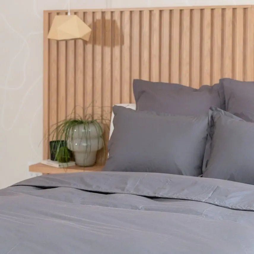 Slate Gray bedding set on a bed with a wooden headboard and decorative items.