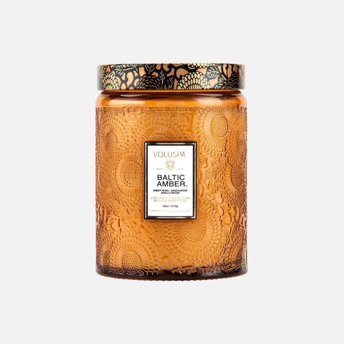 Voluspa baltic amber decorative candle in a textured glass jar with a gold pattern lid