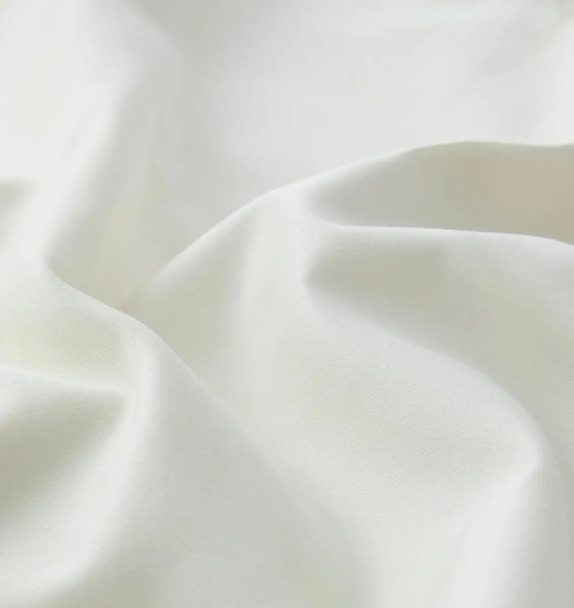 Close-up of an ivory white sheet set fabric with folds