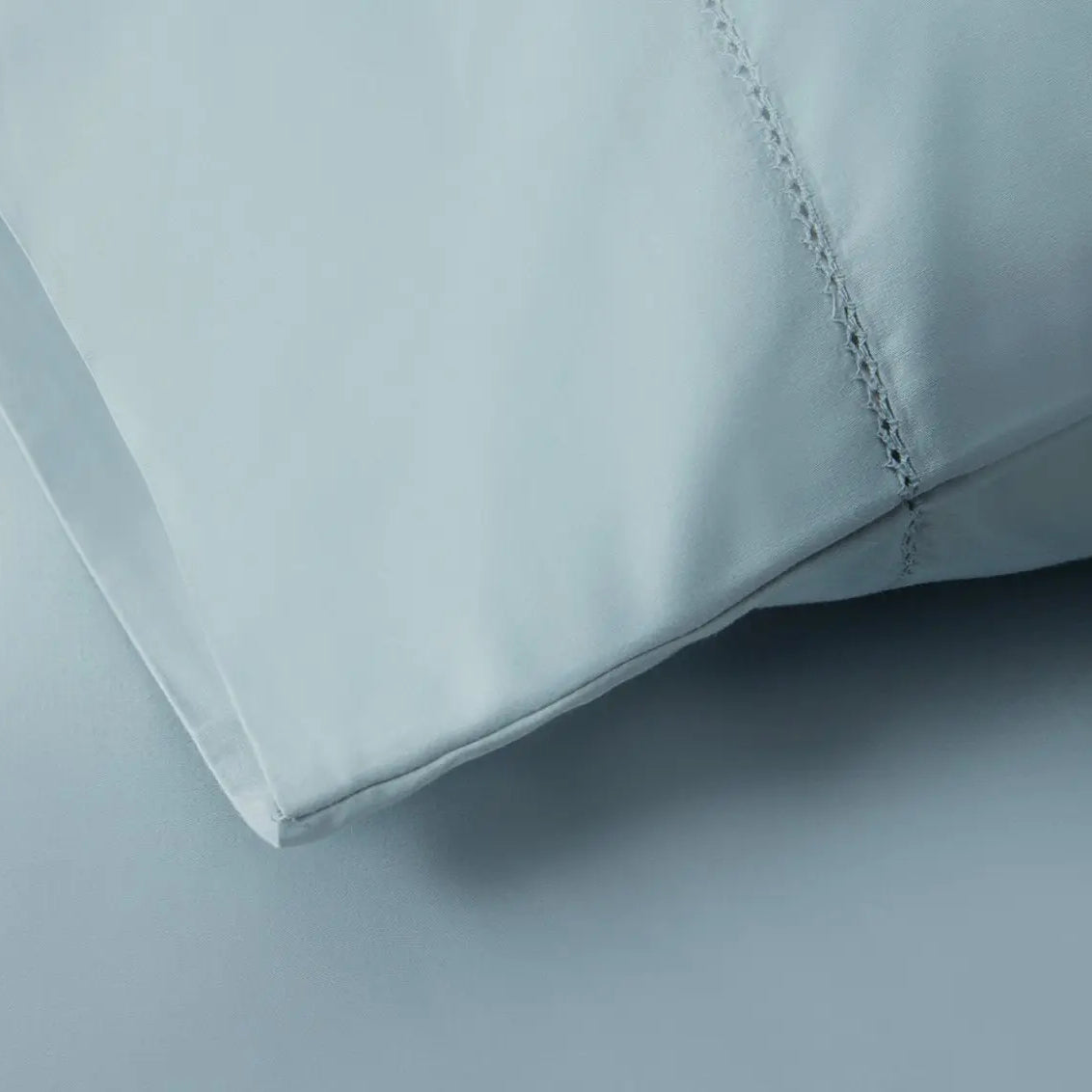 Close-up of a light blue bed sheet fabric with a subtle pattern