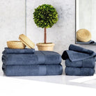 Stacks of blue Premium Turkish Cotton towels on a white surface with decorative items in the background.