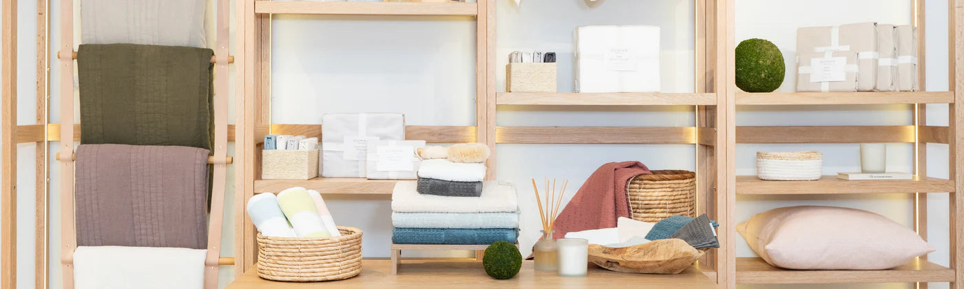 Wooden shelves with various home decor items including towels, baskets, and containers at Duman Home store