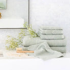 Stack of light mist green towels on a bathroom surface with decorative elements.