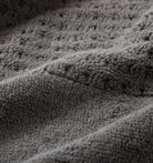 Close-up of textured gray waffle towel fabric with a focus on pattern and texture.