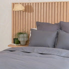 Slate Gray bedding set on a bed with a wooden headboard and decorative items.