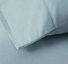 Close-up of a light blue bed sheet fabric with a subtle pattern 