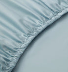 Close-up of a light blue fitted sheet on a bed