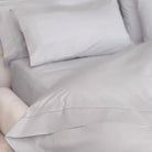 Gray sheet set bedding with pillows on a bed